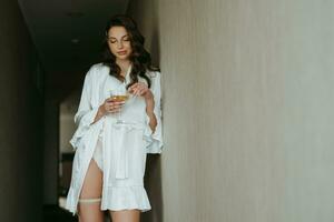 brown-haired girl in the morning in a bathrobe in the hotel corridor with photo