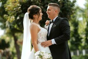 the groom in a brown suit and the bride in a white dress photo