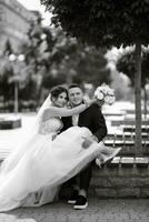 the groom in a brown suit and the bride in a white dress photo