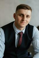 portrait of a cheerful groom in a blue suit photo