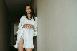 brown-haired girl in the morning in a bathrobe in the hotel corridor with photo