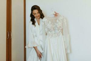 brown-haired girl puts on a wedding dress photo