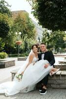 el novio con traje marrón y la novia con vestido blanco foto