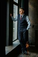 portrait of a cheerful groom in a blue suit photo