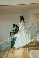 young girl bride in a long wedding dress goes to meet the groom photo