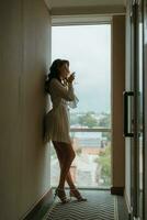 brown-haired girl in the morning in a bathrobe in the hotel corridor with photo