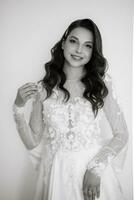 brown-haired girl puts on a wedding dress photo