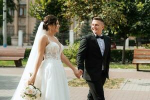 the groom in a brown suit and the bride in a white dress photo