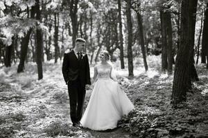 the groom and the bride are walking in the forest photo