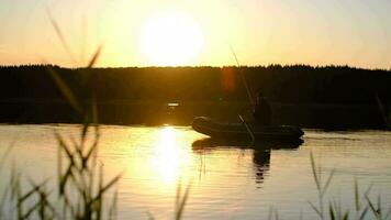 Angeln beim Meer, Fischer im ein Boot, Angeln während Sonnenuntergang, aktiv ausruhen. ein Alten Fischer im ein Boot wirft ein Angeln Stange in das Wasser beim Sonnenuntergang. video