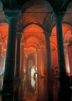 Basilica Cistern with red orange ambient lights. Landmarks of Istanbul. AKA Yerebatan Sarnici. Noise and grain included. Selective focus. Istanbul, Turkey - August 6, 2022. photo