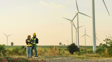 ingenieros son trabajando con viento turbinas, verde ecológico poder energía generación, y sostenible molino campo granjas alternativa renovable energía para limpiar energía concepto. foto