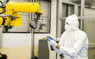 Technician engineers check robot arms and repair automatic robotic machines at the industrial factory, Workers working with focused repairing robotic arms in the industry. photo