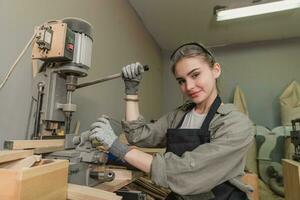 Female Carpenter Wearing Protective Safety Glasses and Using Electric Work on a Wood. Artist or Furniture Designer Working on a Product Idea in a Workshop. photo