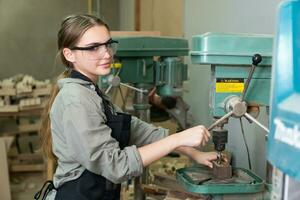 Female Carpenter Wearing Protective Safety Glasses and Using Electric Work on a Wood. Artist or Furniture Designer Working on a Product Idea in a Workshop. photo