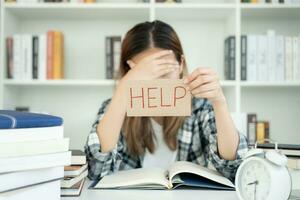 Asian student woman have anxiety because of exams, female prepare for test and learning lessons in the library. stress, despair, haste, misunderstanding reading, discouraged, expectation, knowledge photo