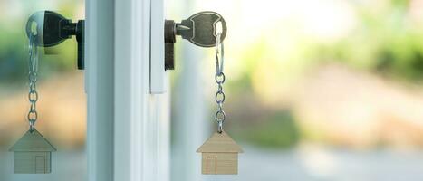 la llave del propietario para desbloquear la casa está enchufada en la puerta. casa de segunda mano en alquiler y venta. llavero está soplando en el viento. hipoteca para casa nueva, compra, venta, renovación, inversión, propietario, patrimonio foto