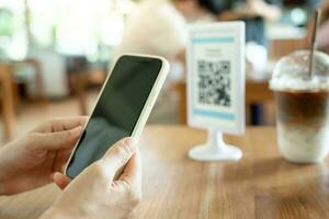 Woman use smartphone to scan QR code for order menu in cafe restaurant with a digital delivery. Choose menu and order accumulate discount. E wallet, technology, pay online, credit card, bank app. photo