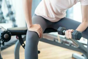 woman is lifting the Dumbbell up and down for strengthen her arms and shoulders. exercisers and are checking how to exercise properly. correct exercise. diet, body shape, healthy, strong photo