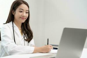 telemedical. Doctors are read record of patients an interview video conference. Asian doctor is treating patients through telecommunication while describing the disease . Technology for health. photo