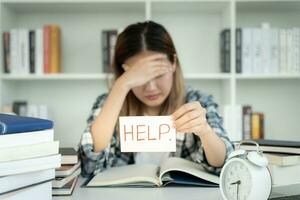 Asian student woman have anxiety because of exams, female prepare for test and learning lessons in the library. stress, despair, haste, misunderstanding reading, discouraged, expectation, knowledge photo