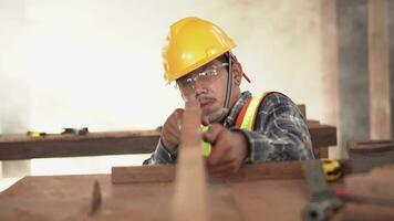 A attractive hardworking young professional male carpenter worker looking and choosing wood in the workshop. video