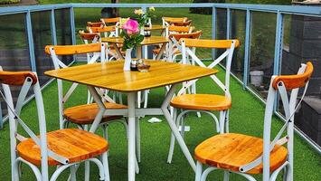 de madera mesa y sillas en un verano café en el verde césped foto