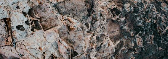 Sea cracked granite textured rock concept photo. Mediterranean sea rough surfaces. photo