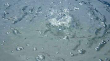 water giet in de water met spatten en bubbels. hoog kwaliteit 4k beeldmateriaal video