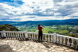 Young woman at a viewpoint over the beautiful Sopo valley at the department of Cundinamarca in Colombia photo