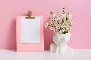 Empty sheet paper with head shape vase with spring bloom flowers on pink background photo