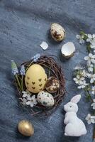 Pascua de Resurrección composición con nido, blanco Conejo y huevos plano poner, parte superior vista. foto