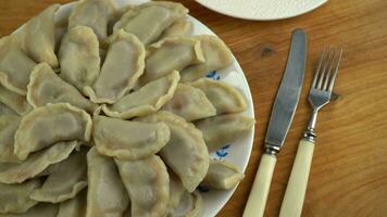 Wareniki mit Kirschen. traditionell ukrainisch Lebensmittel. Knödel auf ein Platte. Kochen von gekocht Teig mit Obst Füllung. video