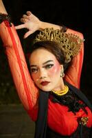 a Balinese woman wears heavy makeup with rosy red lips and sharp hair when posing photo