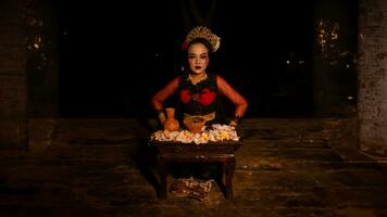 a female dancer sits gracefully and begins her ritual in front of beautiful offerings photo