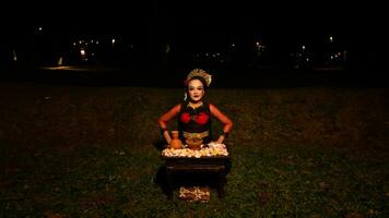 a female dancer performs a ritual that creates a magical and mystical atmosphere in front of flower offerings photo