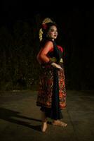 an Asian woman poses in red traditional clothes and jewelry on her head photo