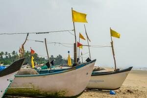 antiguo pescar barcos en arena en Oceano en India en azul cielo antecedentes foto