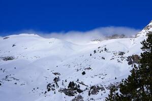 Fresh ski slope and mountains in sunny day photo