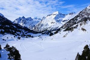 Fresco esquí Pendiente y montañas en soleado día foto