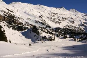 Fresh ski slope and mountains in sunny day photo