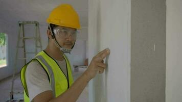 The foreman is checking the color consistency of the walls, looked from the side and touched professionally. video