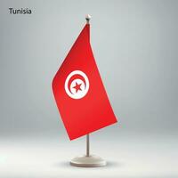 Flag of Tunisia hanging on a flag stand. vector