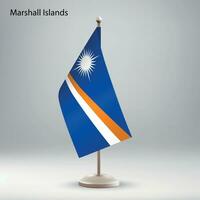 Flag of Marshall Islands hanging on a flag stand. vector