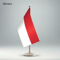 Flag of Monaco hanging on a flag stand. vector