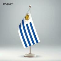 Flag of Uruguay hanging on a flag stand. vector