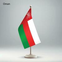 Flag of Oman hanging on a flag stand. vector