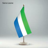 Flag of Sierra Leone hanging on a flag stand. vector