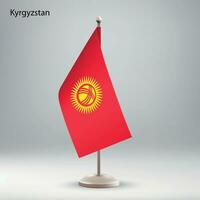 Flag of Kyrgyzstan hanging on a flag stand. vector