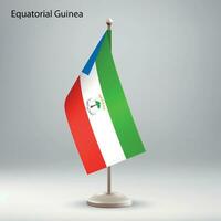 Flag of Equatorial Guinea hanging on a flag stand. vector